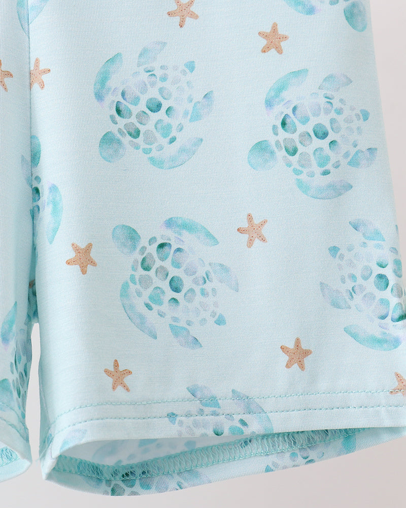 Light blue fabric with turtle and starfish pattern on a white background