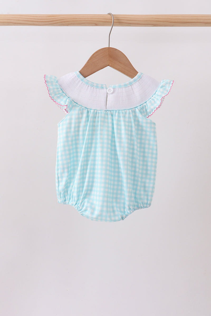 Light blue checkered baby romper with white collar on a wooden hanger against a light background