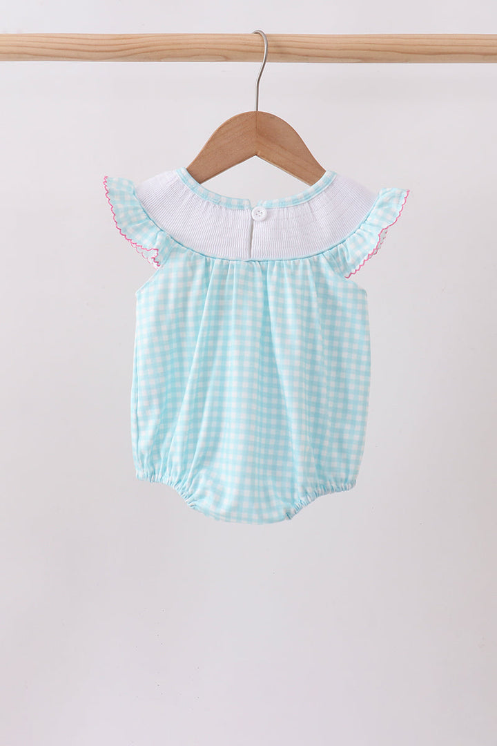 Light blue checkered baby romper with white collar on a wooden hanger against a light background