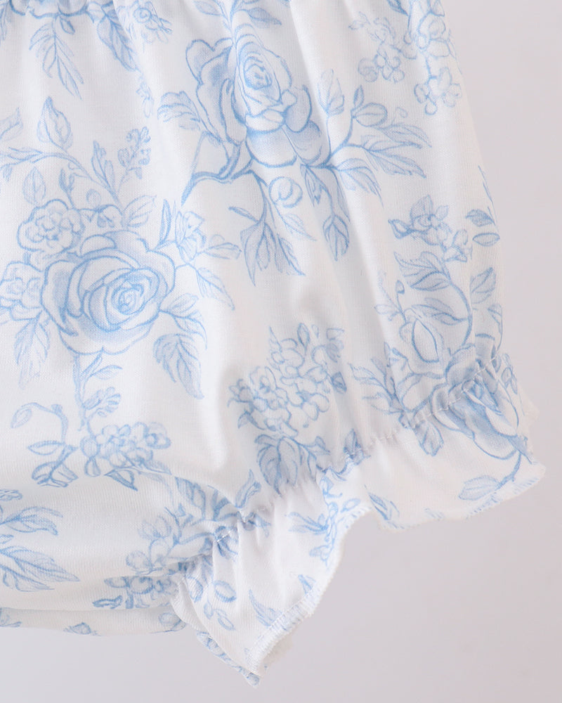 White fabric with blue floral pattern on a light gray background
