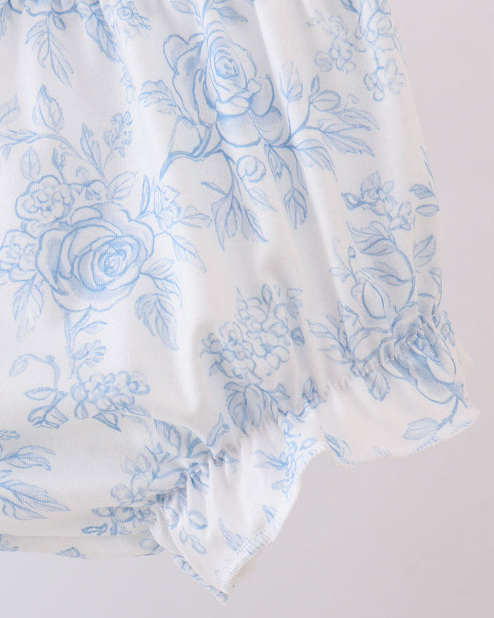 White fabric with blue floral pattern on a light gray background