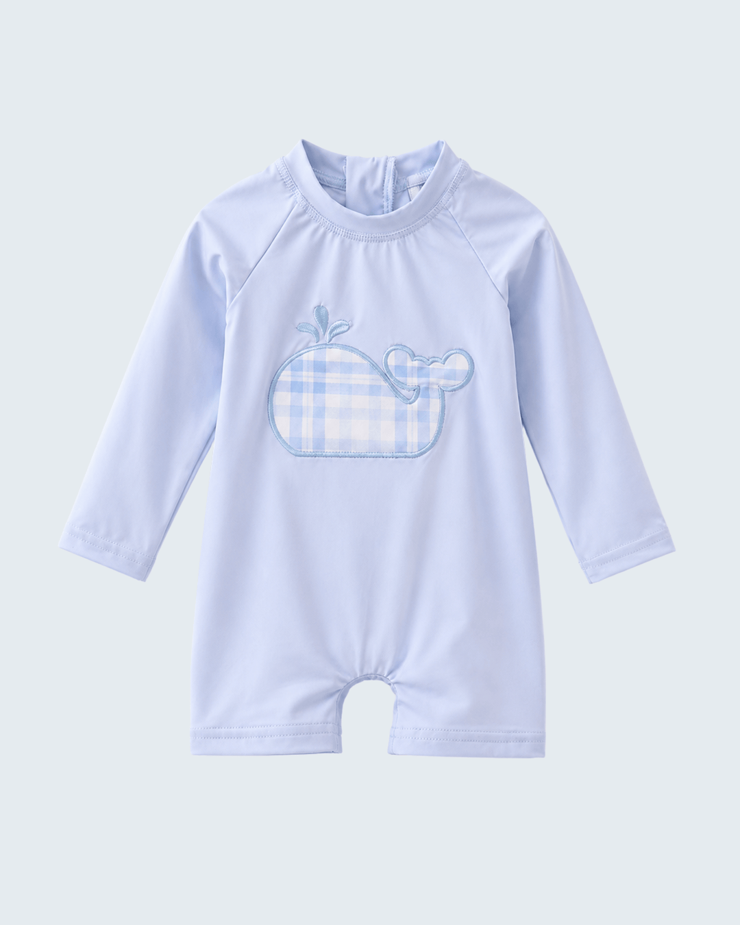 Light blue baby swimsuit with whale design on a light gray background