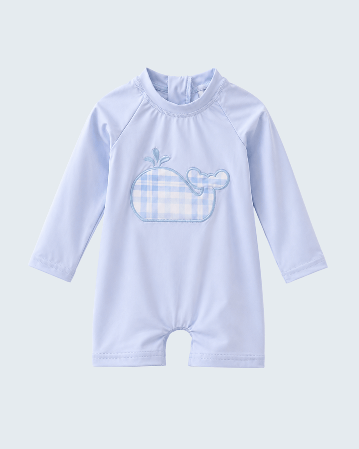 Light blue baby swimsuit with whale design on a light gray background