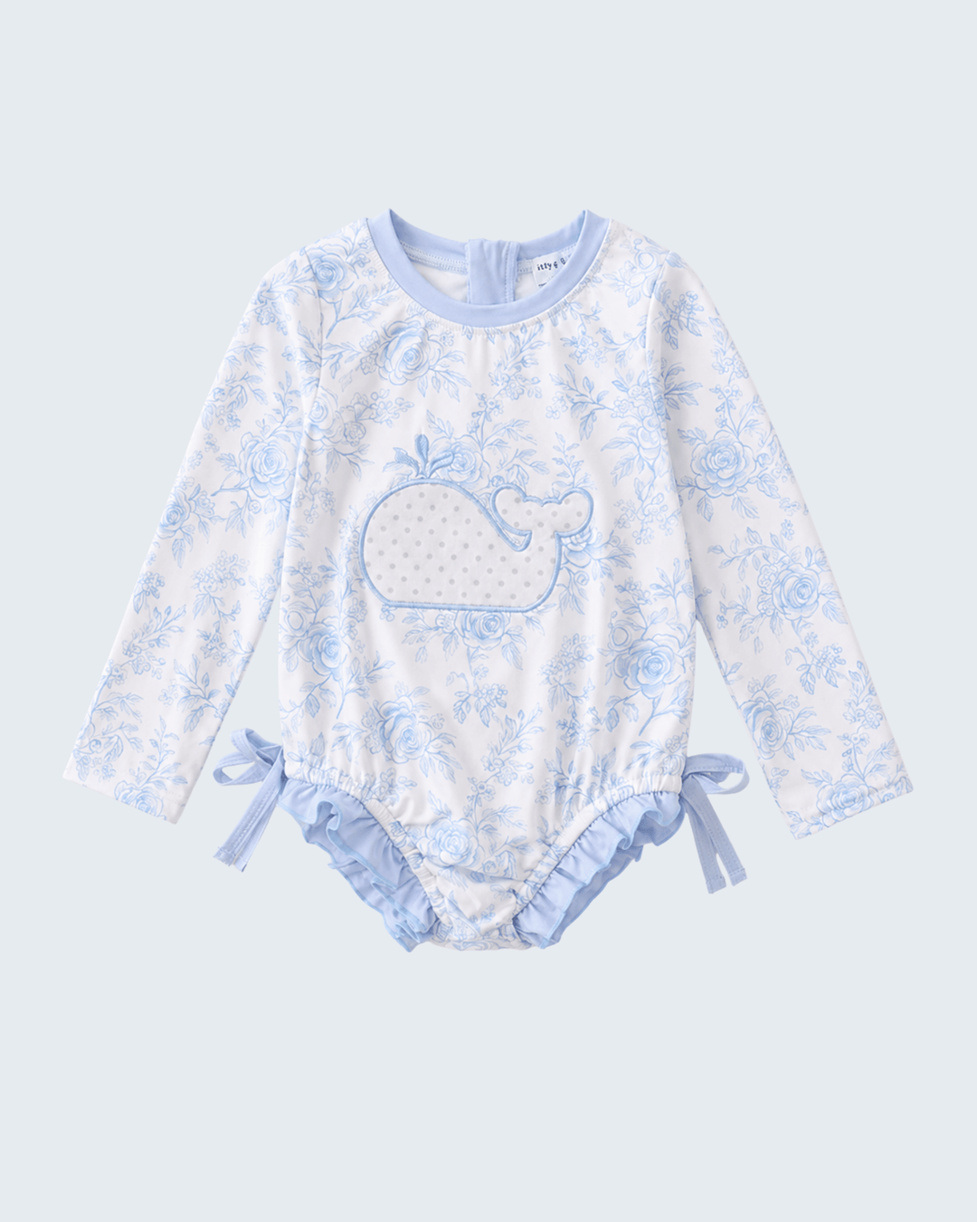 Baby rashguard with whale design on a light blue background