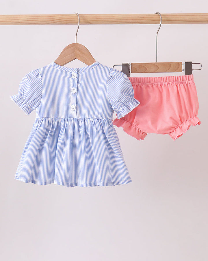 Baby dress with short sleeves and pink bloomers on hangers against a light background