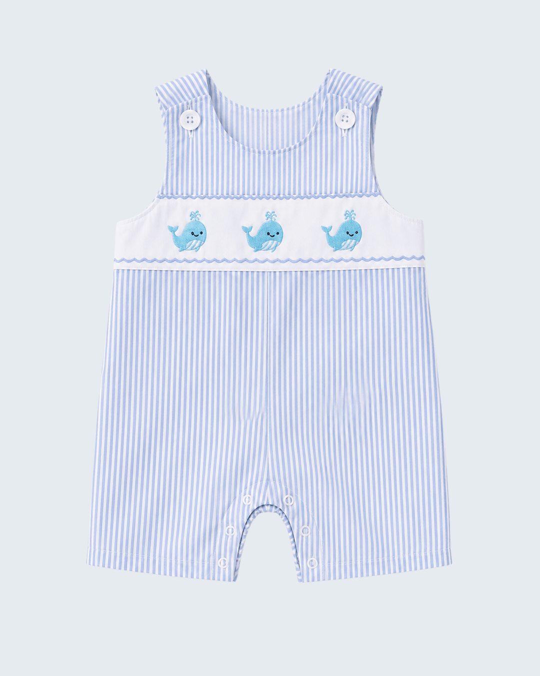 Blue and white striped baby romper with whale designs on a light blue background