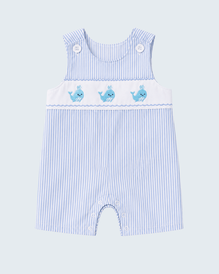 Blue and white striped baby romper with whale designs on a light blue background