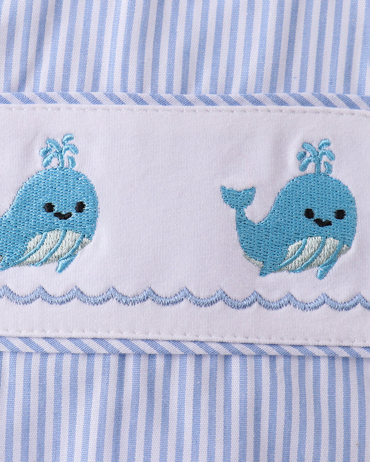 Embroidered blue whales on a white background with blue striped border