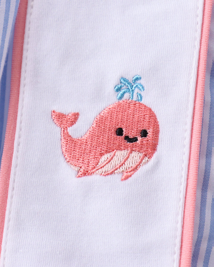 Embroidered pink whale design on a white background with pink and blue borders.