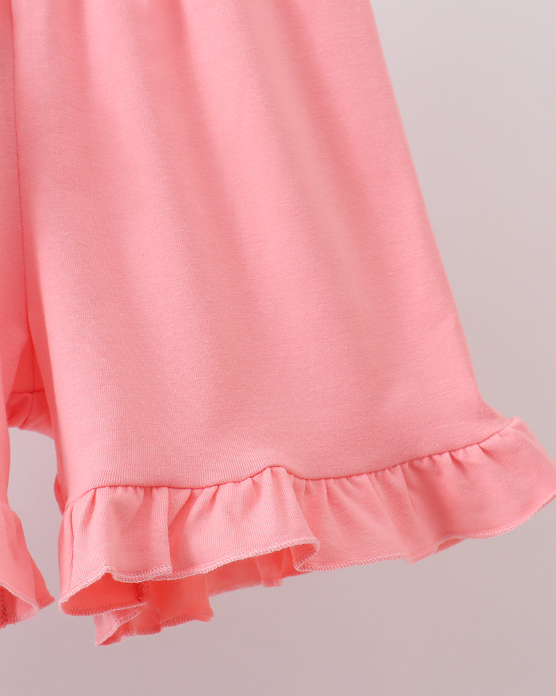 Close-up of a pink shorts with ruffled hem on a light gray background