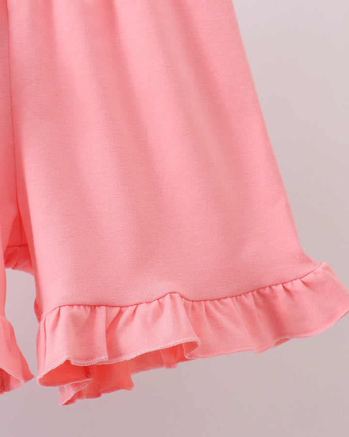 Close-up of a pink shorts with ruffled hem on a light gray background