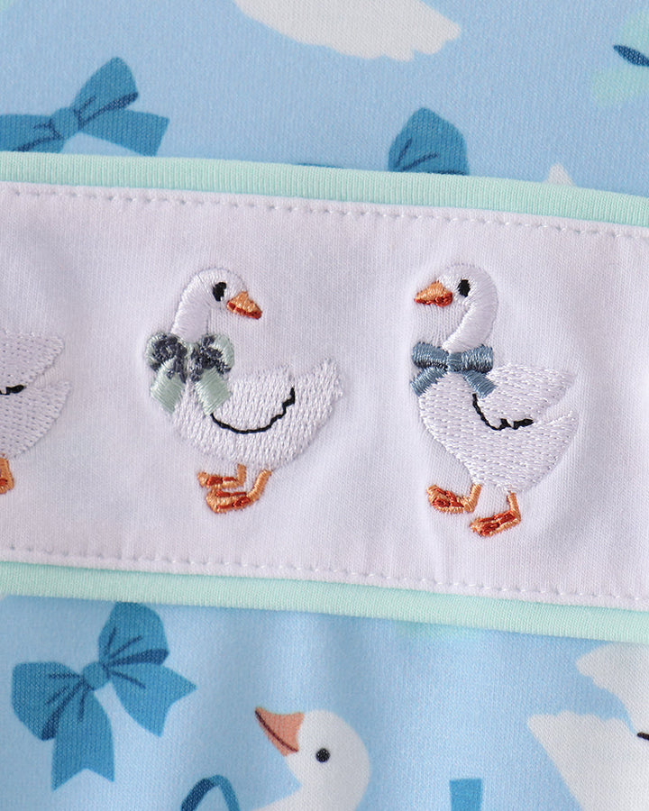 White goose face embroidery with small bow details on light blue ruffle romper