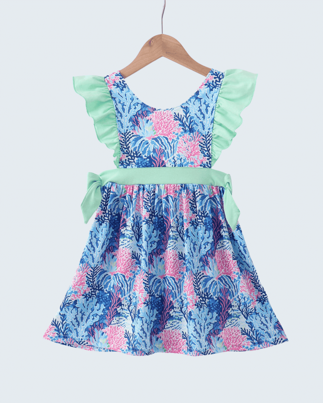 Floral dress with ruffled top and skirt on a hanger against a white background