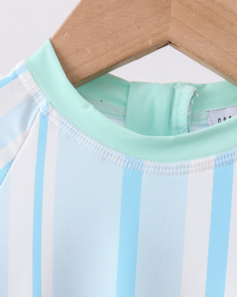 Close-up of a baby outfit with blue and white stripes on a hanger.