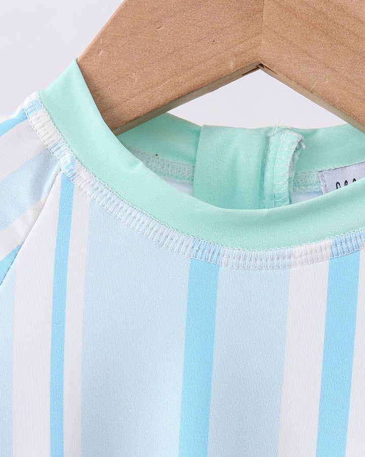 Close-up of a baby outfit with blue and white stripes on a hanger.