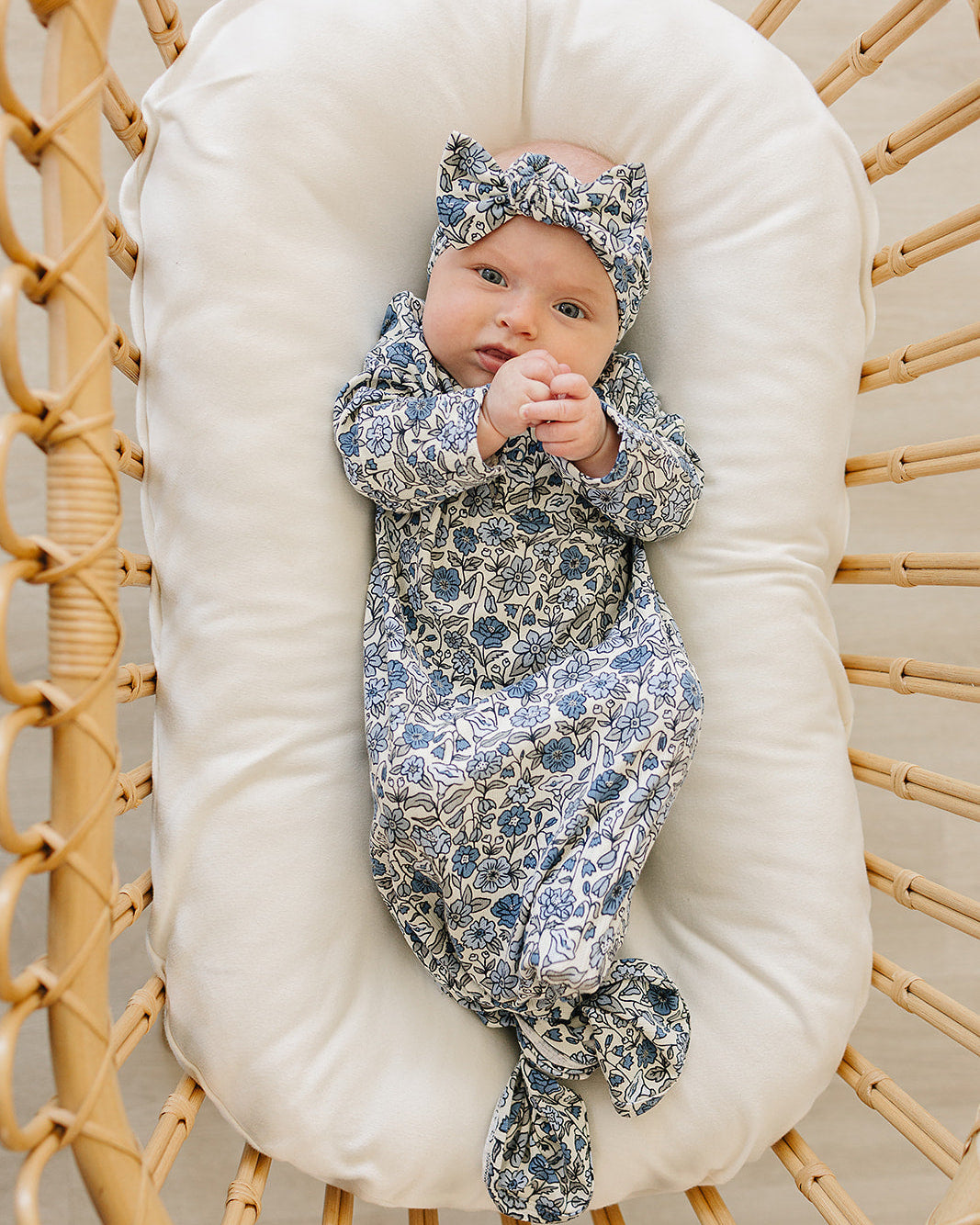 Blue-and-white floral pointelle head wrap with tied bow, shown on baby