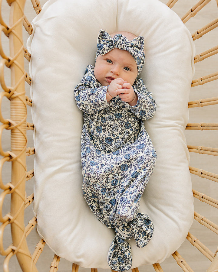 Blue-and-white floral pointelle head wrap with tied bow, shown on baby