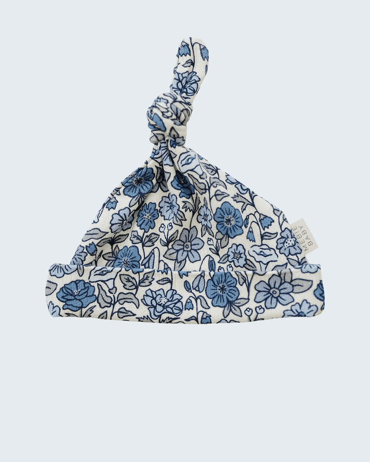 Floral patterned baby knot hat on a light blue background
