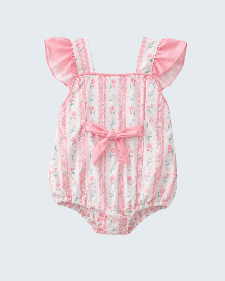 Baby swimsuit with floral pattern and pink trim on a light gray background