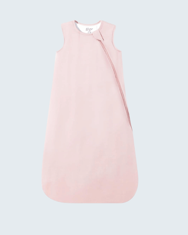 A light pink sleeveless baby sleep sack with a diagonal zipper, shown flat against a light gray background.