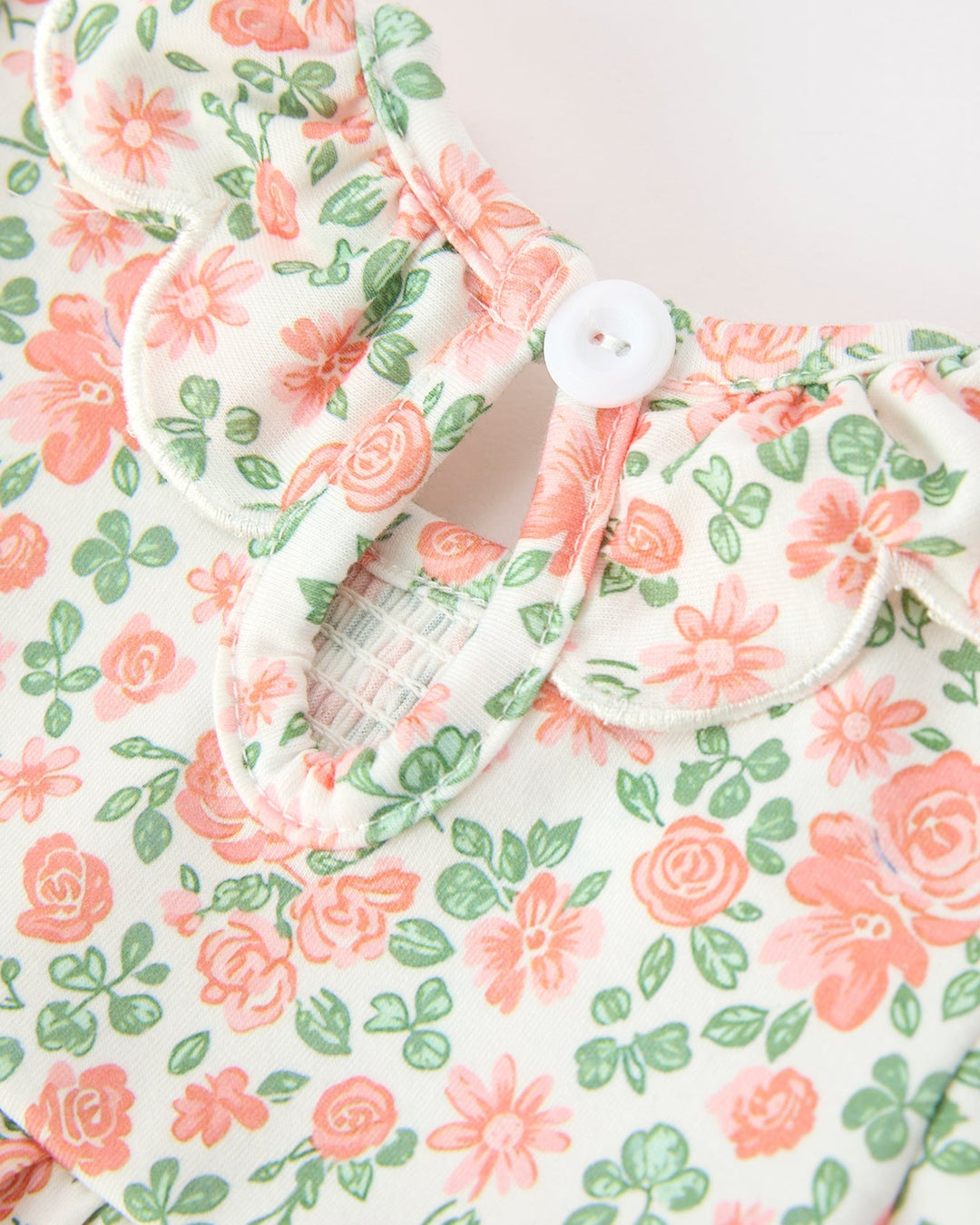 Floral baby romper front with button placket, ruffled petal collar and gathered trim