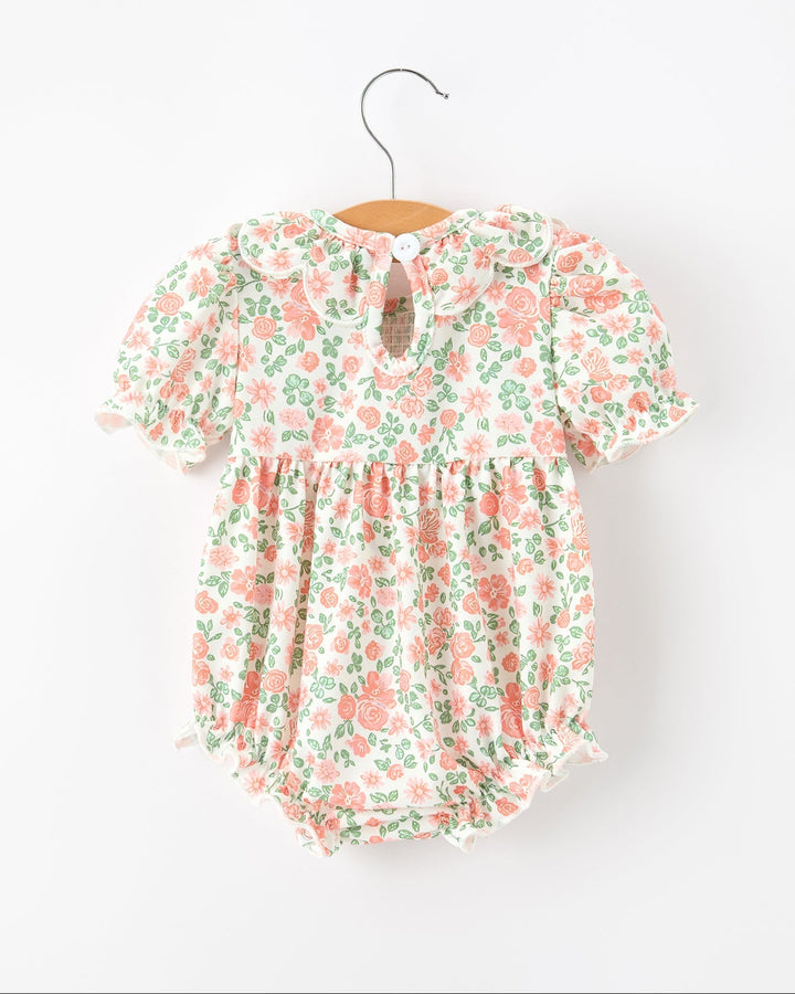 Pastel floral short-sleeve baby romper with ruffled petal neckline and gathered waist