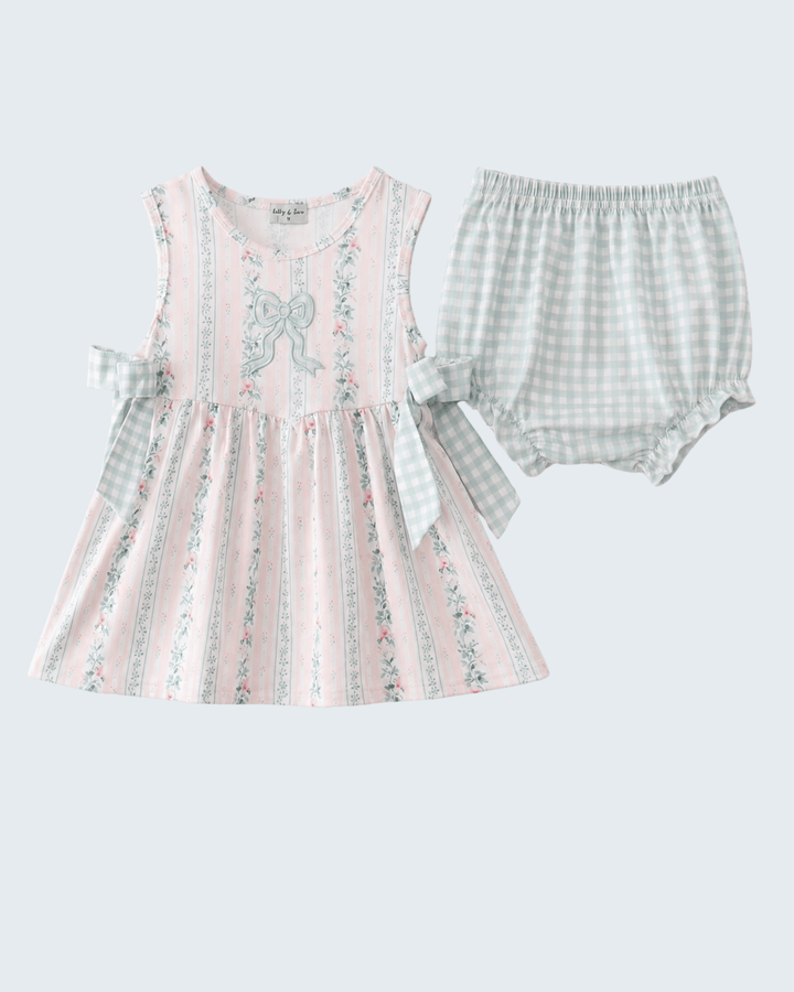 Baby dress with floral pattern and checkered bloomers on a light gray background