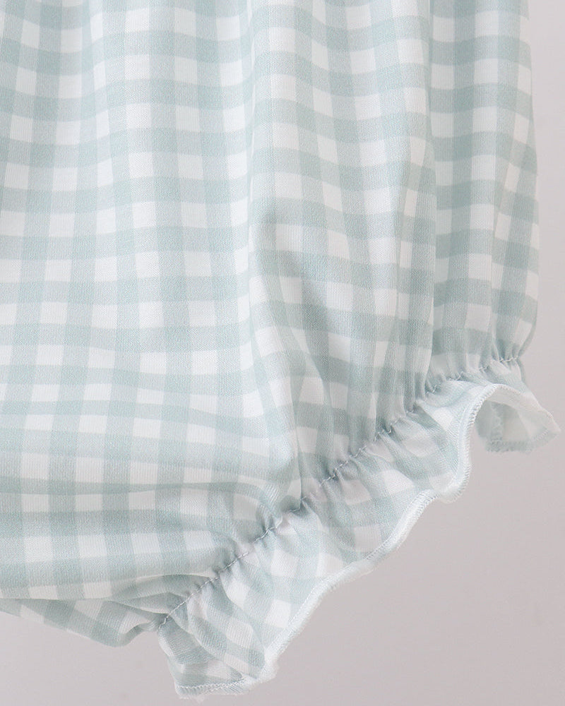 Light blue and white checkered fabric with ruffled edge on a light gray background
