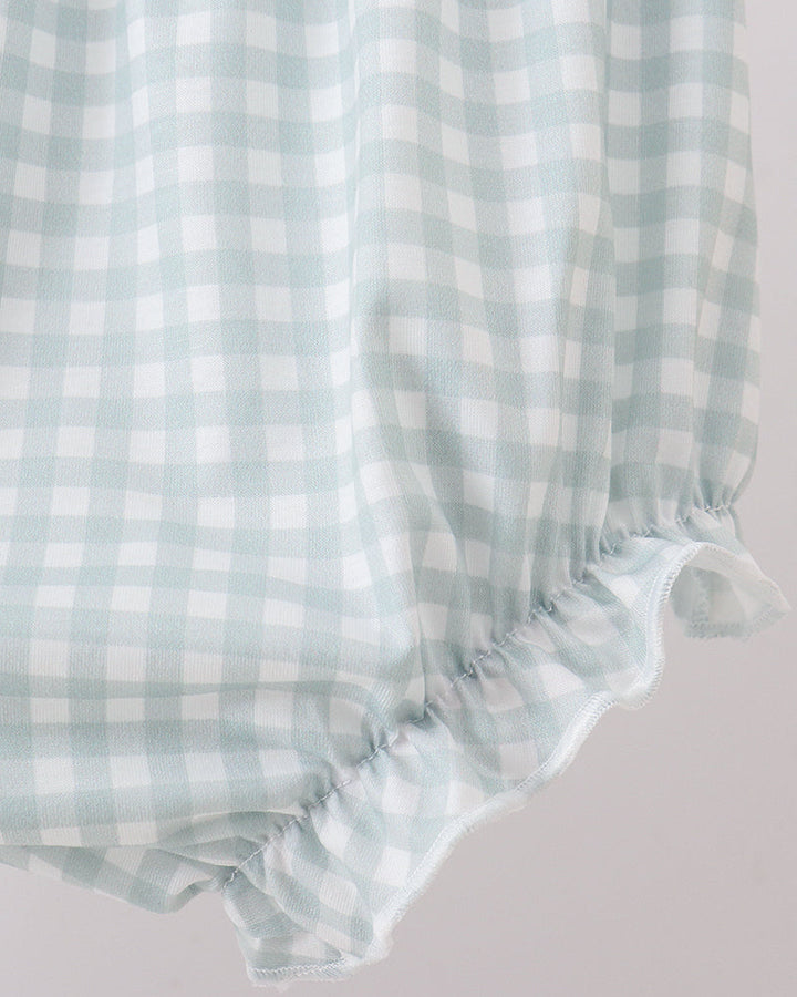 Light blue and white checkered fabric with ruffled edge on a light gray background