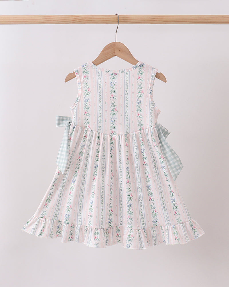 Floral dress hanging on a wooden hanger against a white background