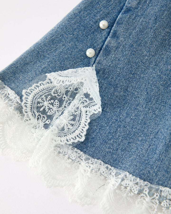 Close-up of girls denim flare jeans with white lace scalloped hem and 2 buttons