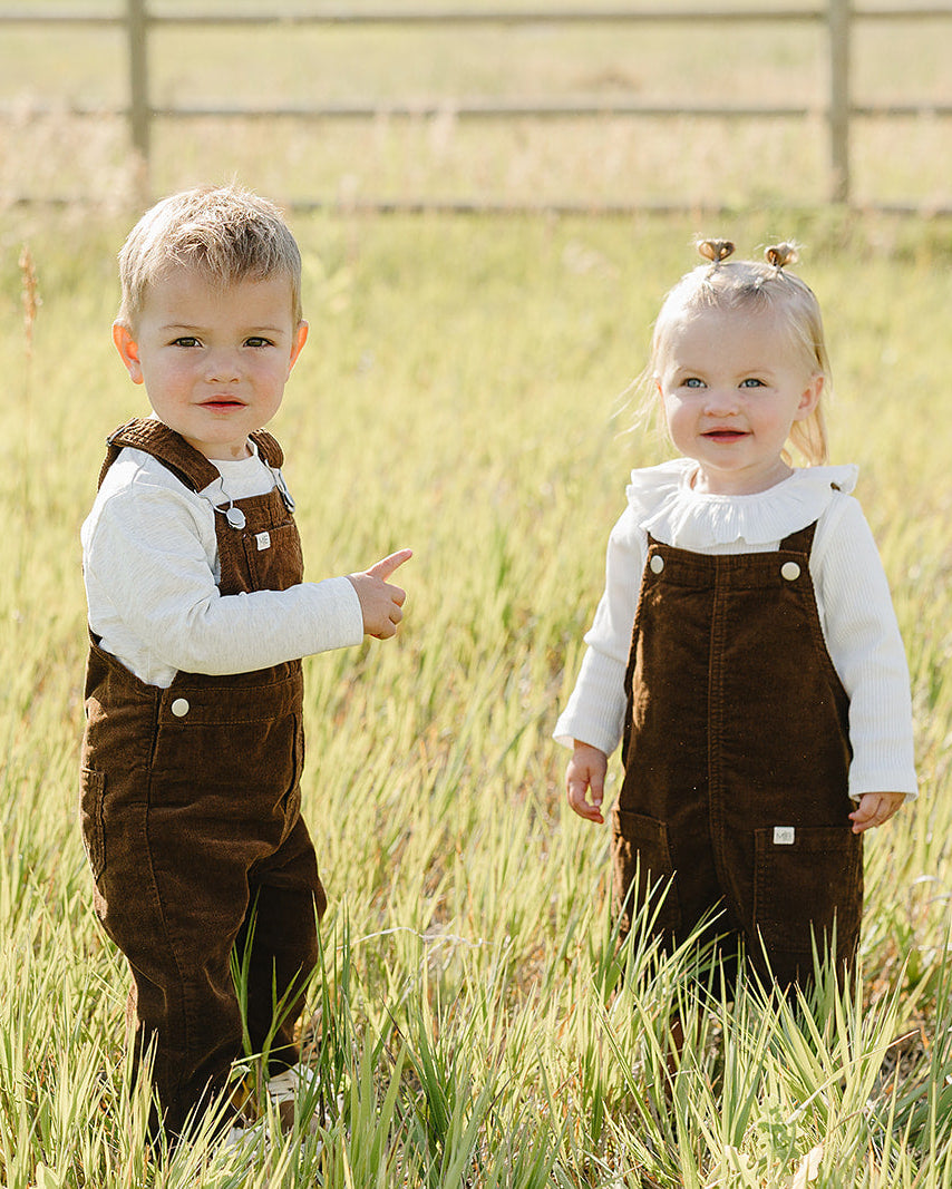 Brown corduroy overall dress with button straps and two front patch pockets