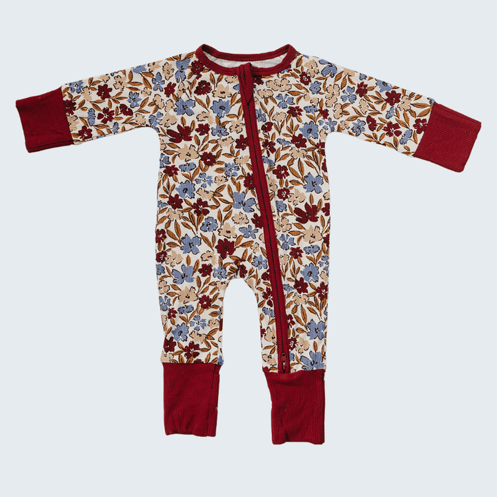 Floral-patterned baby onesie with red accents on a white background