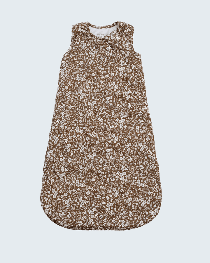 A sleeveless baby sleep sack with a dense brown and white floral pattern, displayed flat against a light gray background.