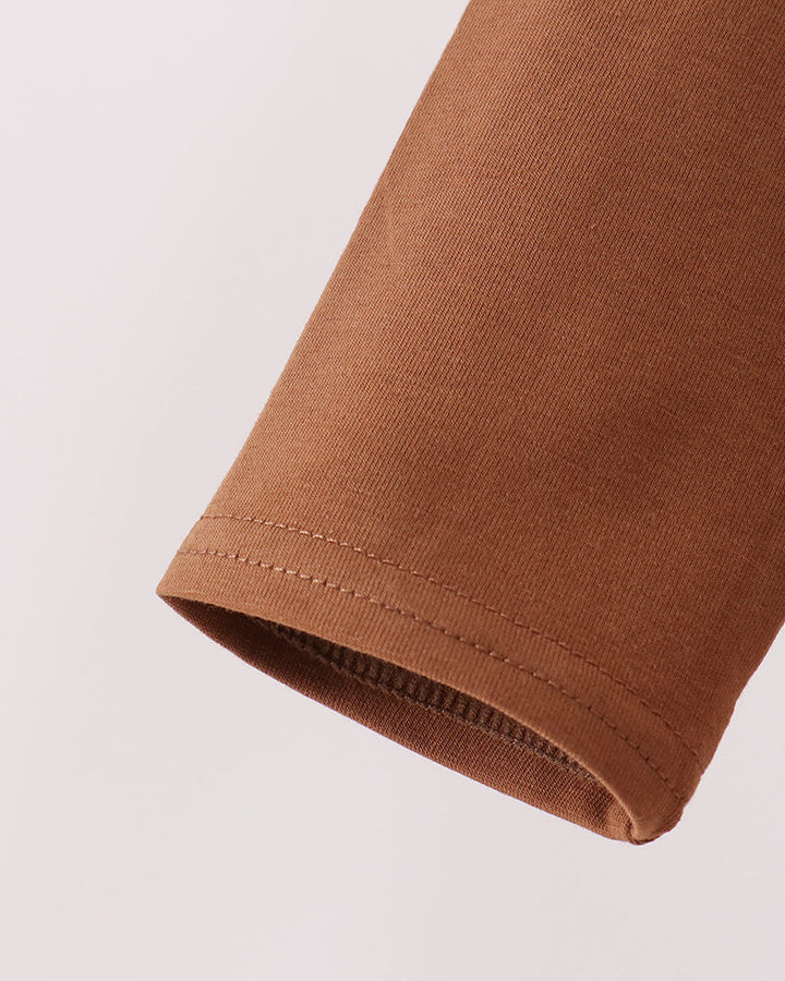 Brown long-sleeve top cuff with double-stitched hem.