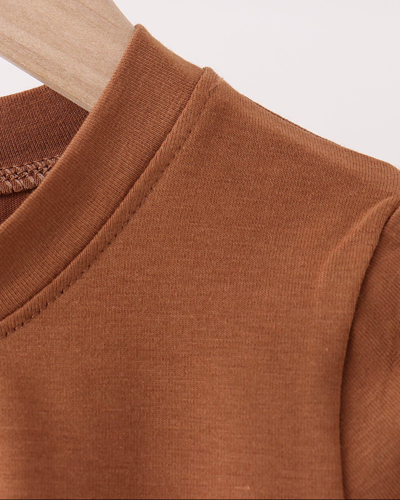 Brown long-sleeve top with round crew neck and stitched shoulder seam.