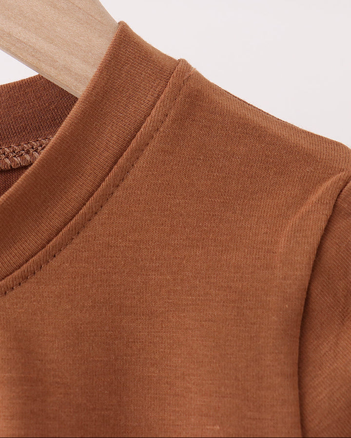 Brown long-sleeve top with round crew neck and stitched shoulder seam.