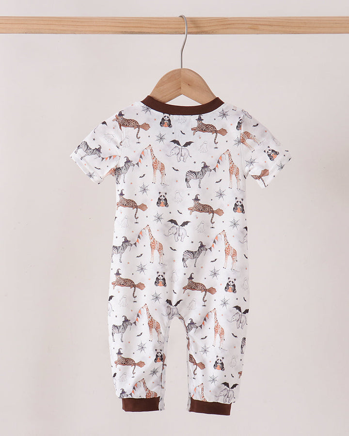 A baby short-sleeve footless romper hanging on a wooden hanger from a wooden rod. The romper has an all-over print of brown and black dogs on a white background, with dark brown ribbed trim at the collar and cuffs.