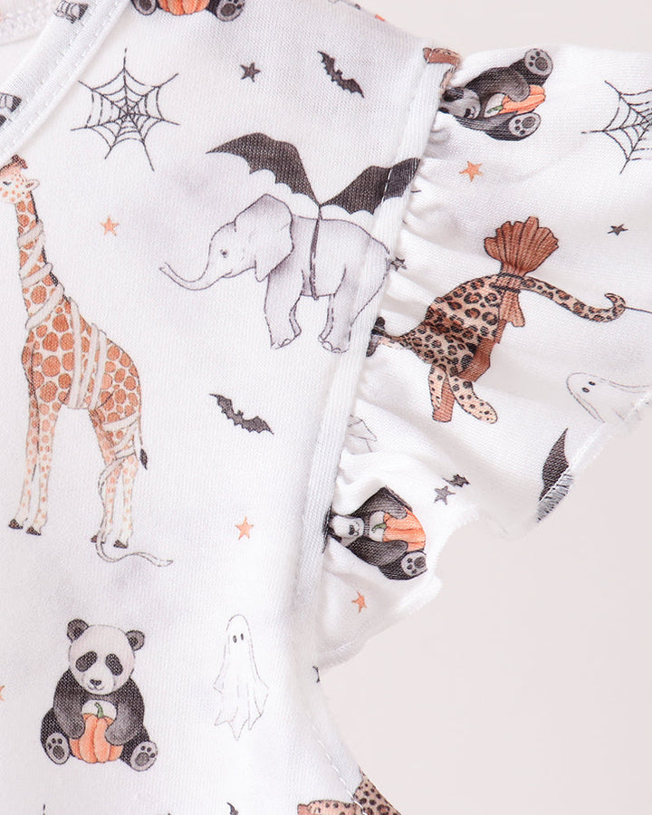 White girls clothing or fabric with a whimsical animal print featuring pandas, giraffes, elephants, leopards, ghosts, bats, and spiderwebs in orange, black, and brown, shown in a close-up studio shot.