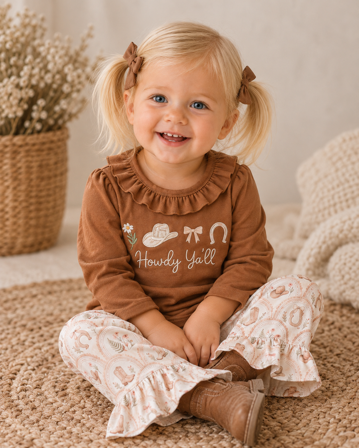 Toddler girl in brown ruffle top and cream patterned flared ruffle pants