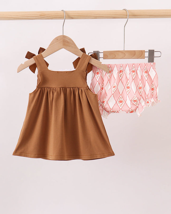 Brown sleeveless dress with bow ties and matching peach patterned bloomer