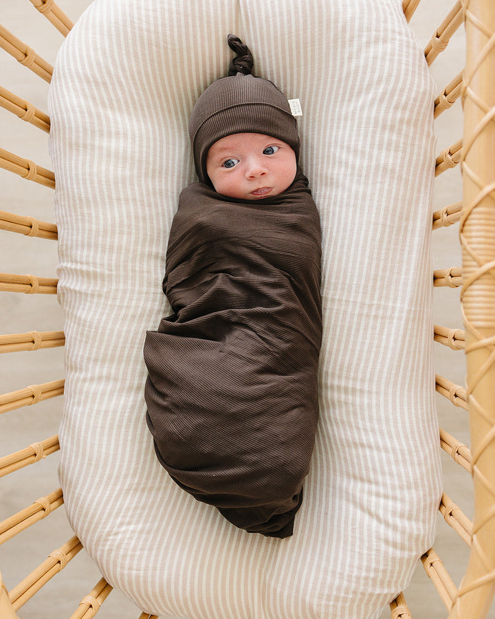Dark brown ribbed newborn knot hat on baby’s head, with gathered top knot.