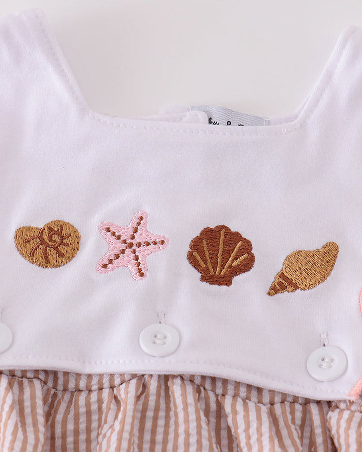 White top with embroidered seashells and starfish on a white background