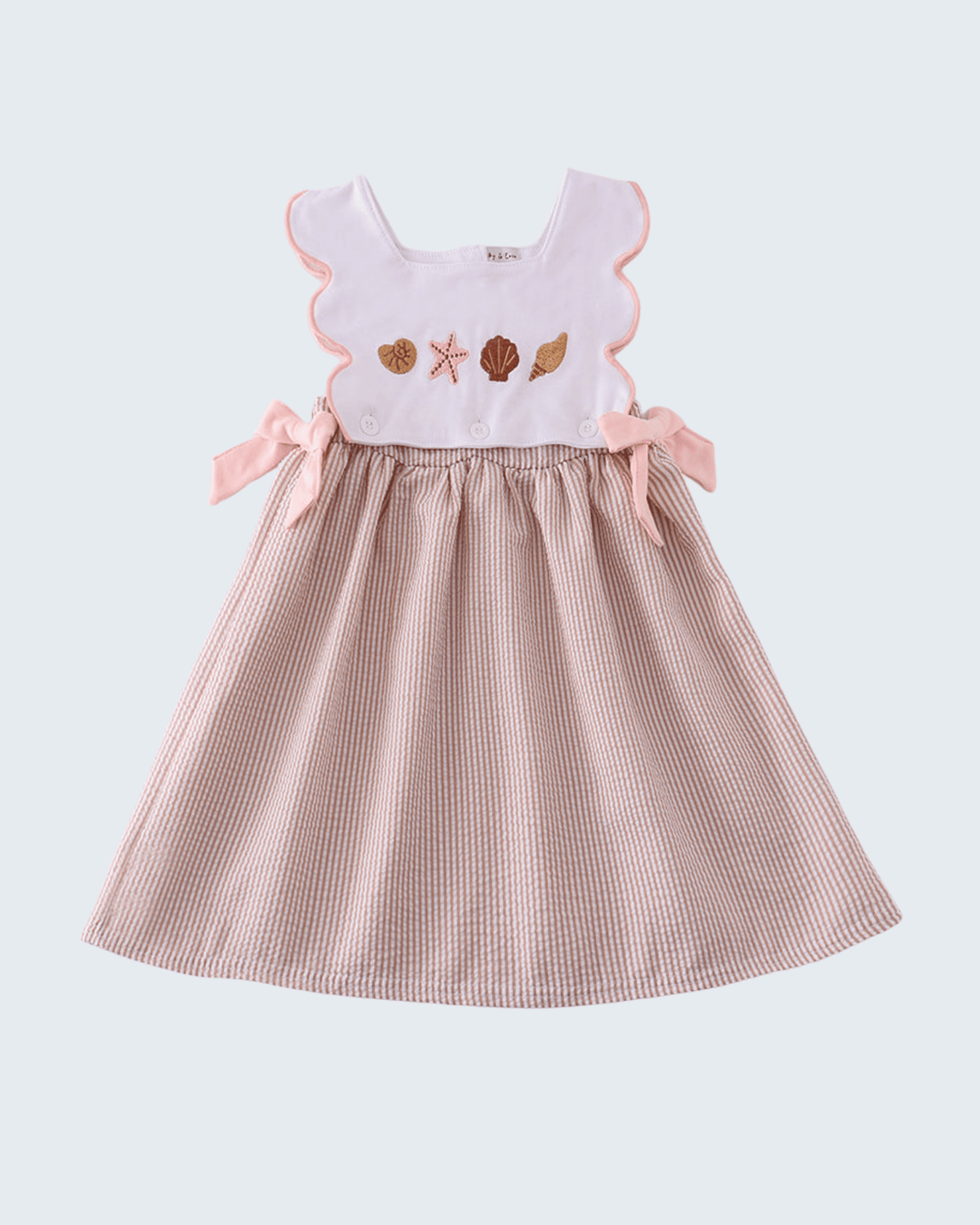 Children's dress with a white top and brown checkered skirt on a light gray background