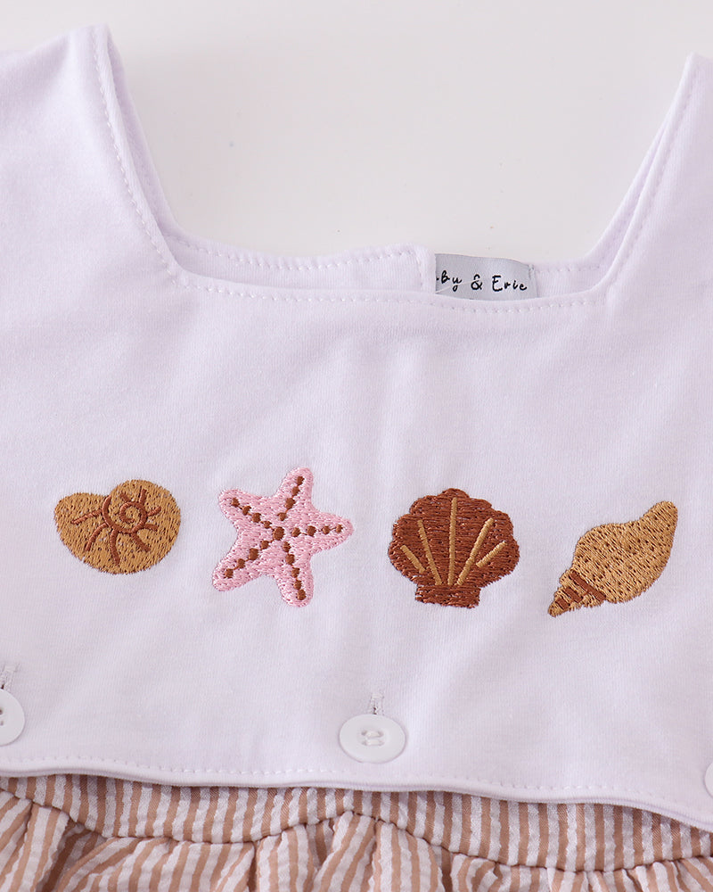 White baby romper with shell and starfish appliqués on a white background