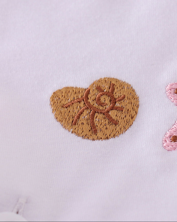 Shell-shaped embroidered design on a light purple fabric
