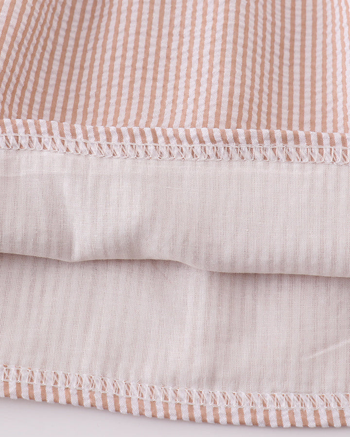 Close-up of striped fabric with pink and white pattern on a light background
