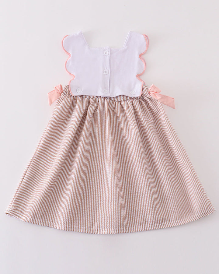 Pink checkered dress with white top on a light gray background
