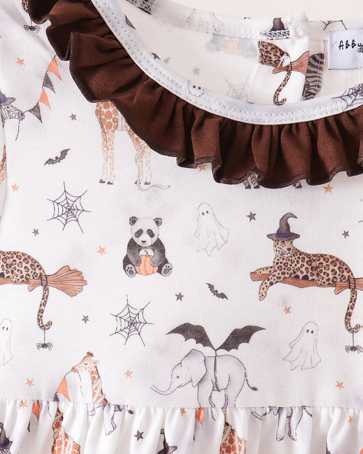 A close-up of a baby dress featuring a white base with a whimsical Halloween print of pandas, leopards, ghosts, and bats, accented by a dark brown ruffled collar and hem.