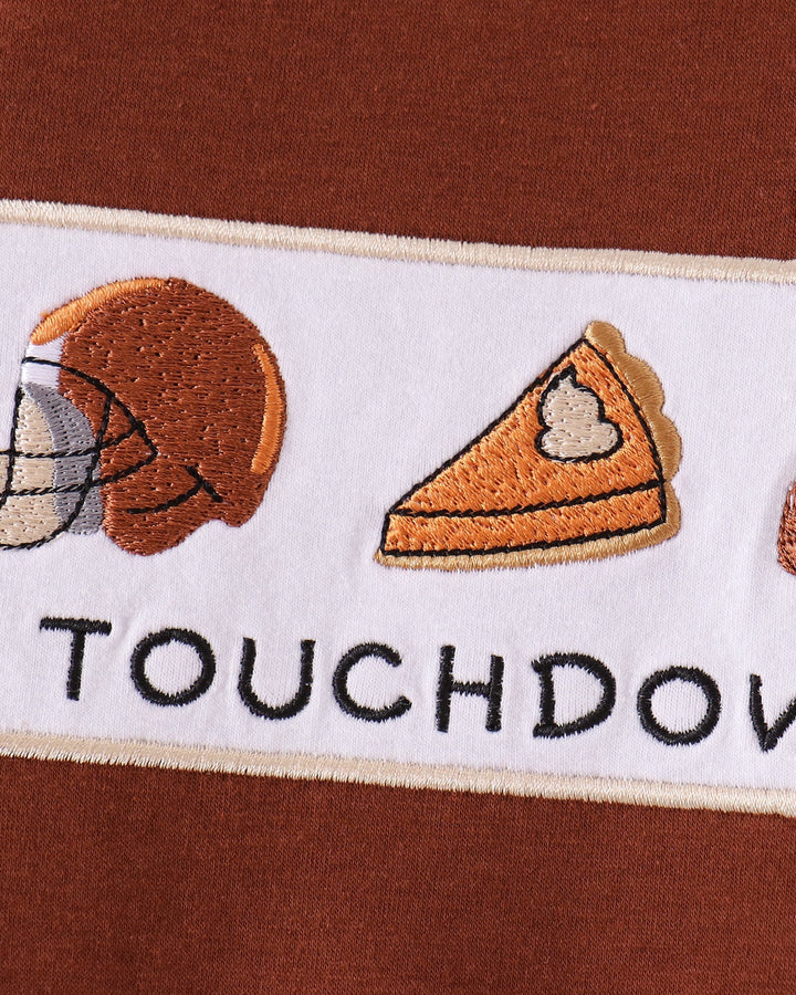 Close-up of touchdown embroidery patch on brown romper front